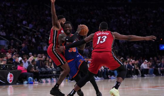 Julius Randle of the New York Knicks, center, drives to the basket against Haywood Highsmith, left, and Bam Adebayo, right, of the Miami Heat in the second half of Saturday's game in New York City.
