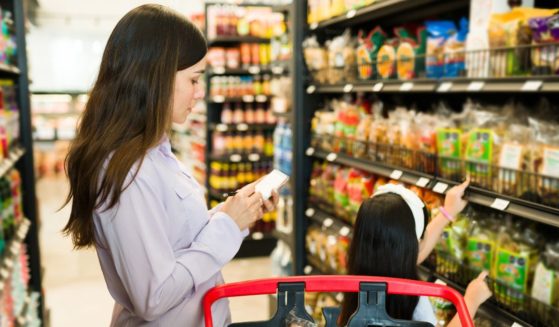 A stock photo shows a woman and her daughter grocery shopping.