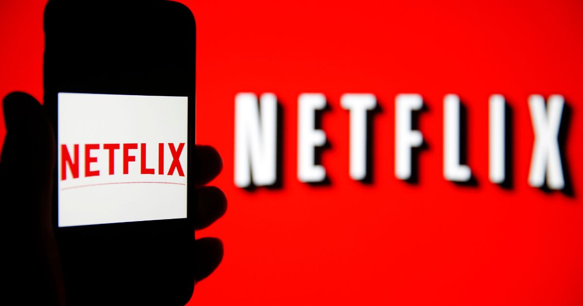 The Netflix logo on a handheld phone.