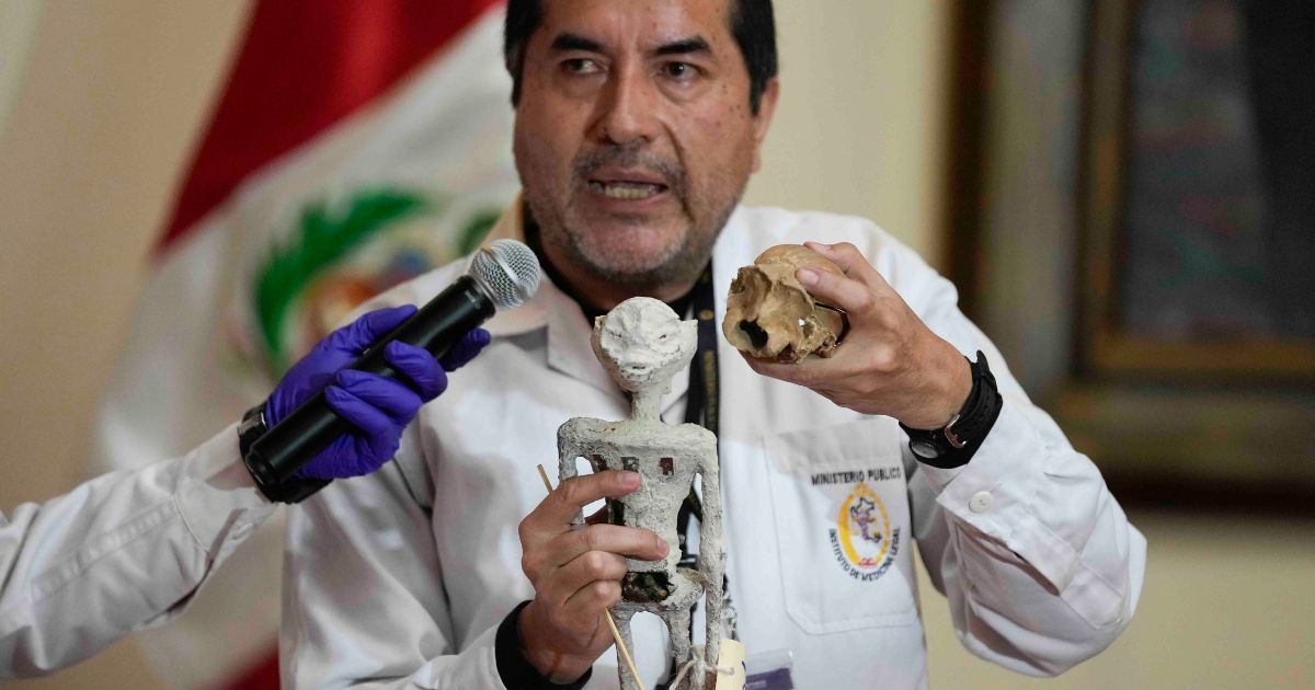 Forensic archaeologist Flavio Estrada shows a doll, which was seized by authorities before it was shipped to Mexico, during a press conference to explain what it is made of at the Archeology Museum in Lima, Peru, Friday.