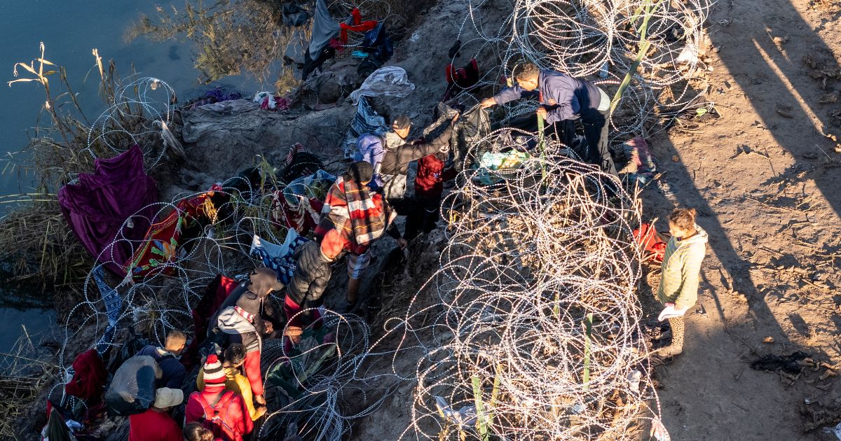 mmigrants climb through razor wire after crossing the Rio Grande from Mexico on Dec. 18 in Eagle Pass, Texas. A surge as many as 12,000 immigrants per day crossing the U.S. southern border has overwhelmed U.S. immigration authorities in recent weeks.