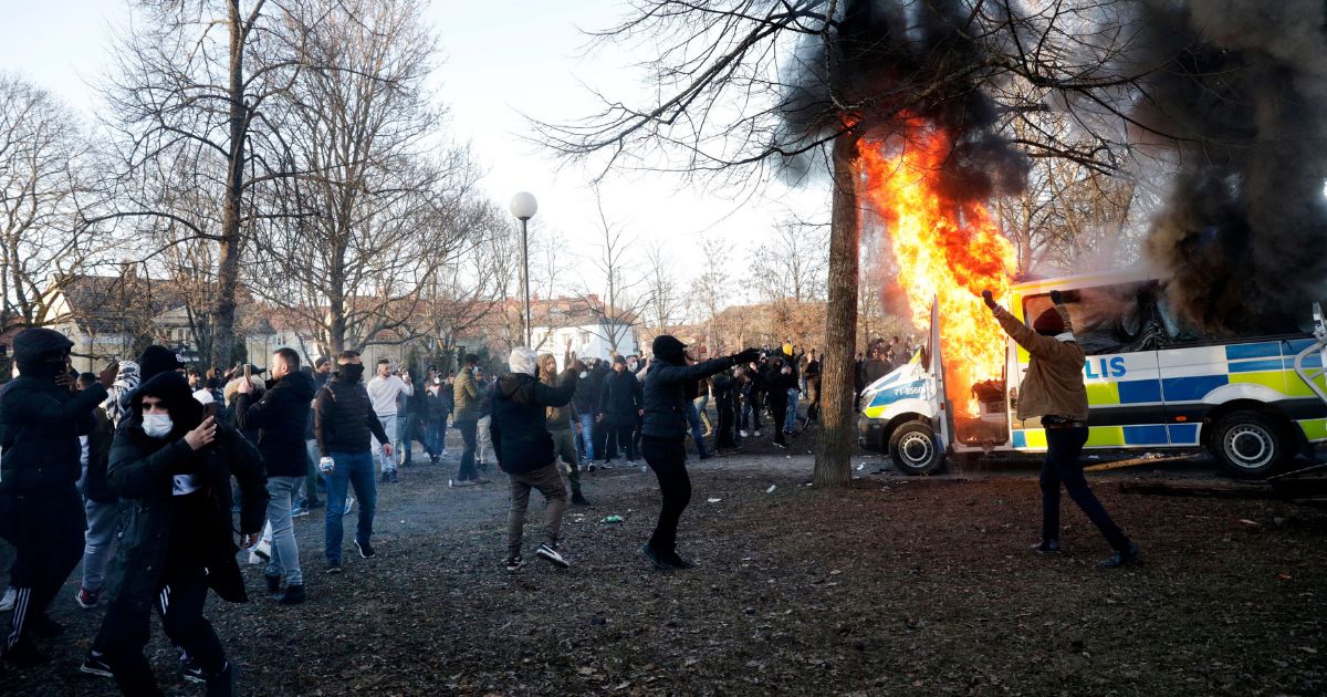 Police vans are on fire as protesters react in the park Sveaparken in Orebro, Sweden, on April 15, 2022.