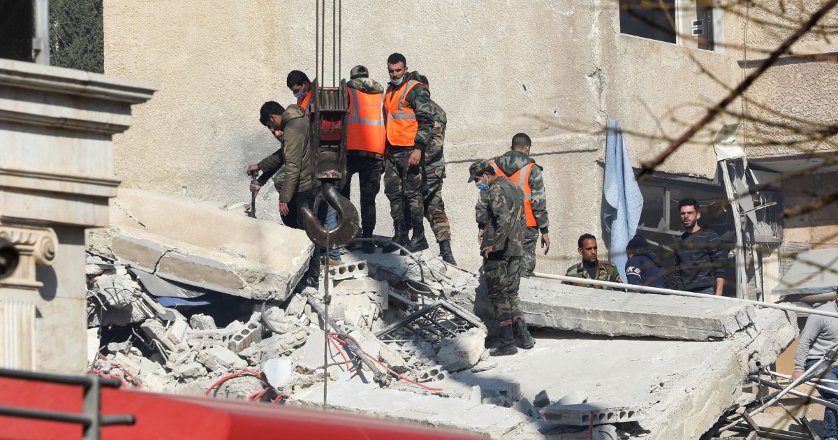 Security and emergency personnel search the rubble of a building destroyed in a reported Israeli strike in Damascus on Saturday.