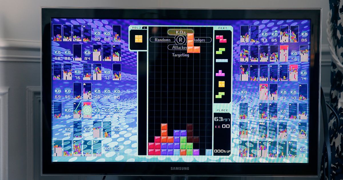 A photo illustration depicts a gamer playing the game Tetris 99.