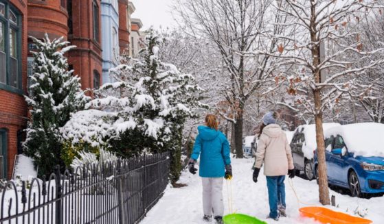 Girls walk through the snowy Capitol Hill neighborhood in Washington D.C. Friday.