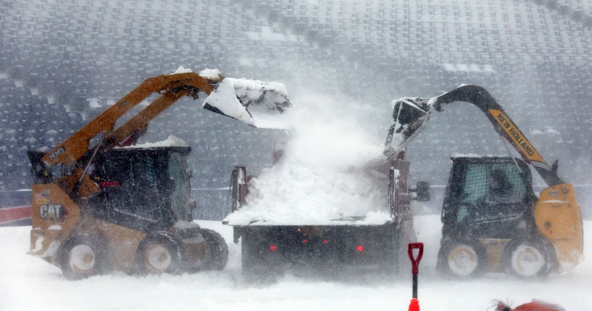 Workers remove snow from Highmark Stadium Sunday in Orchard Park, New York.