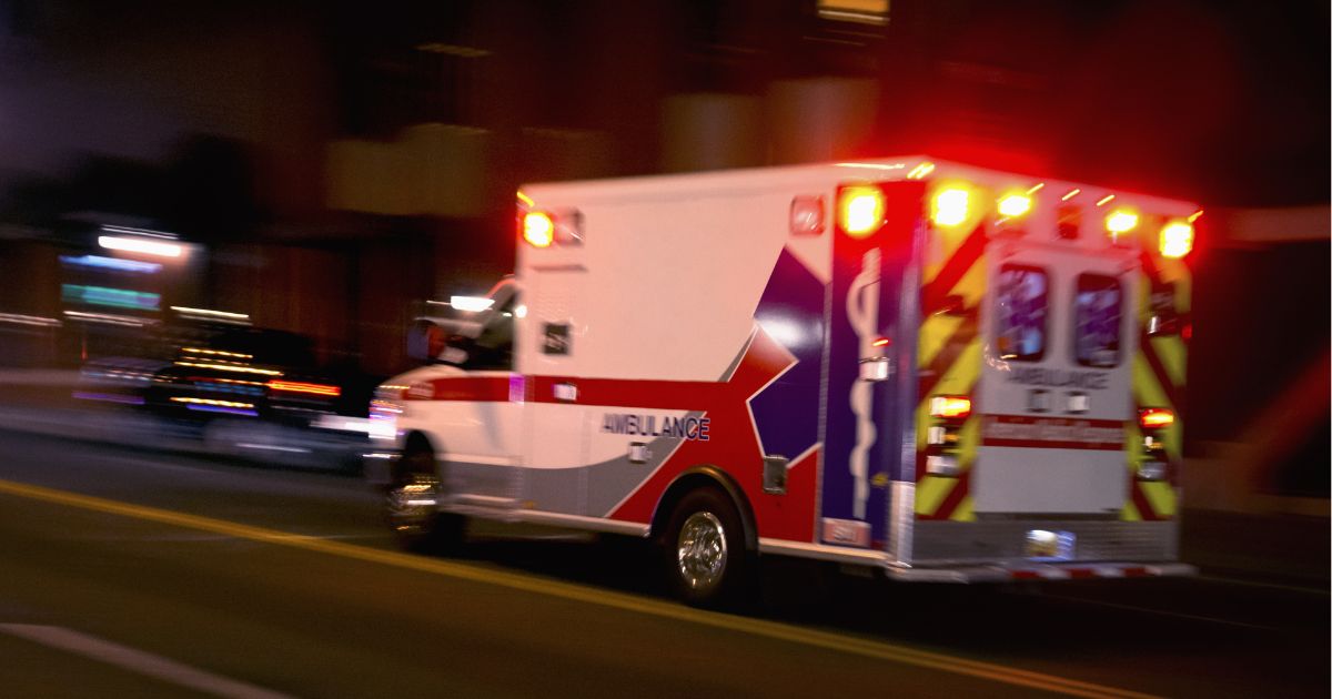 An ambulance speeds down a road in this stock image.