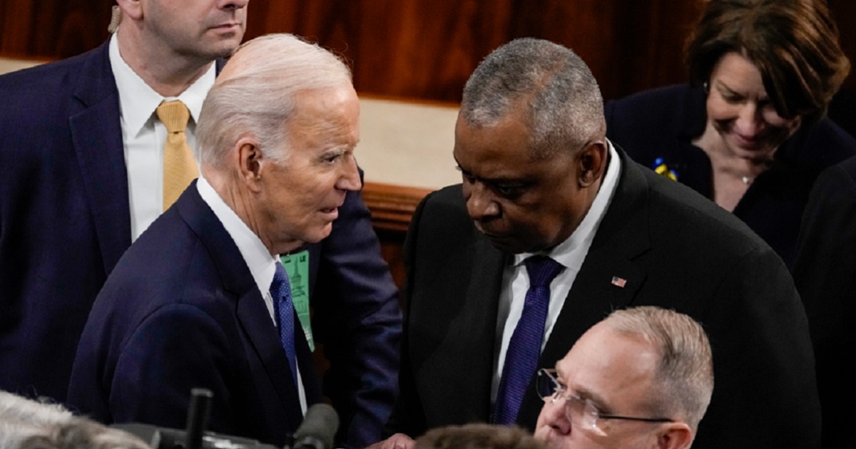 President Joe Biden huddles with Defense Secretary Lloyd Austin in a file photo from after Biden's State of the Union address in February 2023.