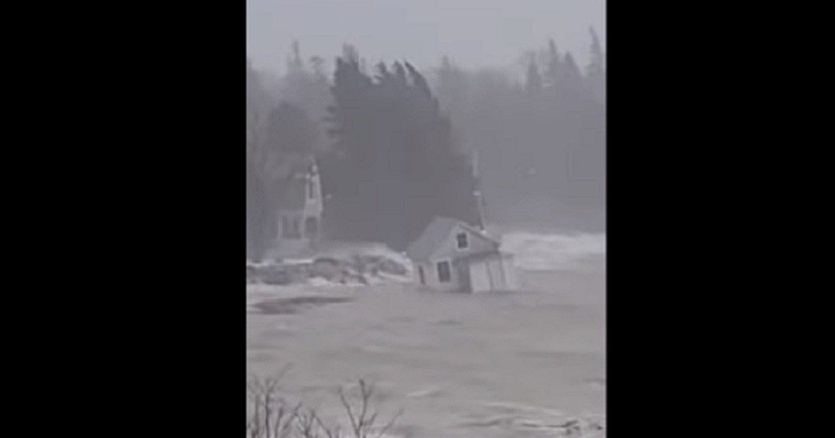 A cabin bobs in the water after being swept off the ground by flood waters in Maine.