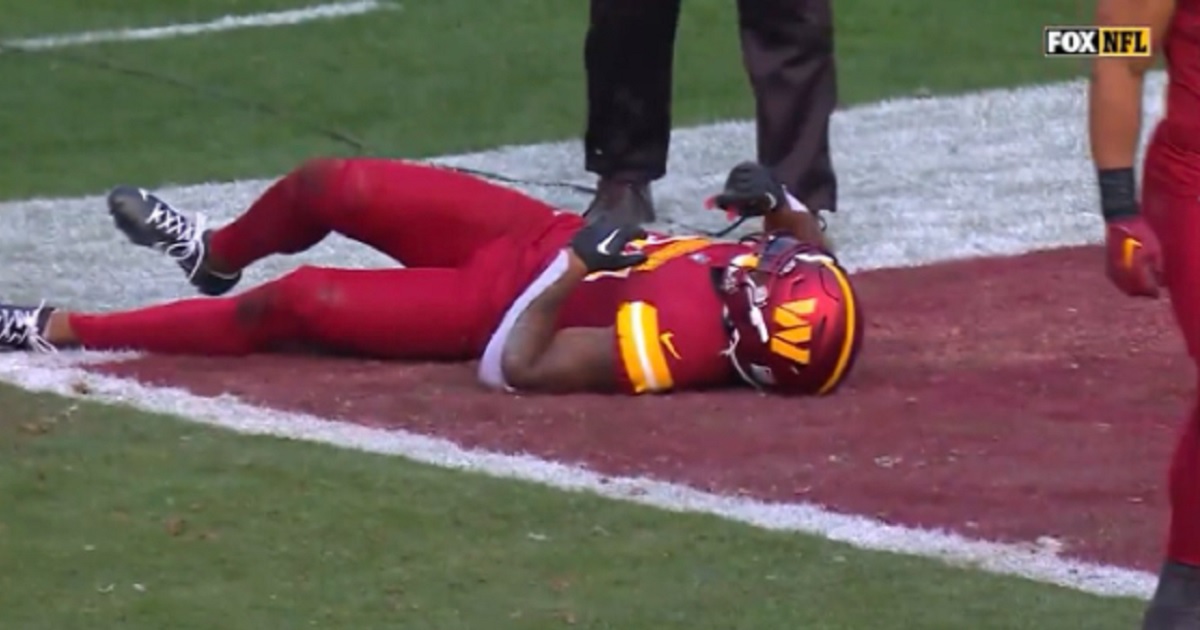 Washington Commanders cornerback Christian Holmes lies on the field after collapsing on Sunday.