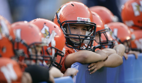 Pop Warner football players look on before an NFL pre-season game between the San Francisco 49ers and the San Diego Chargers in San Diego, California, on Sept. 4, 2009. The California Legislature is considering a bill that would ban children under the age of 12 from competing in tackle football in an effort to reduce brain injuries.