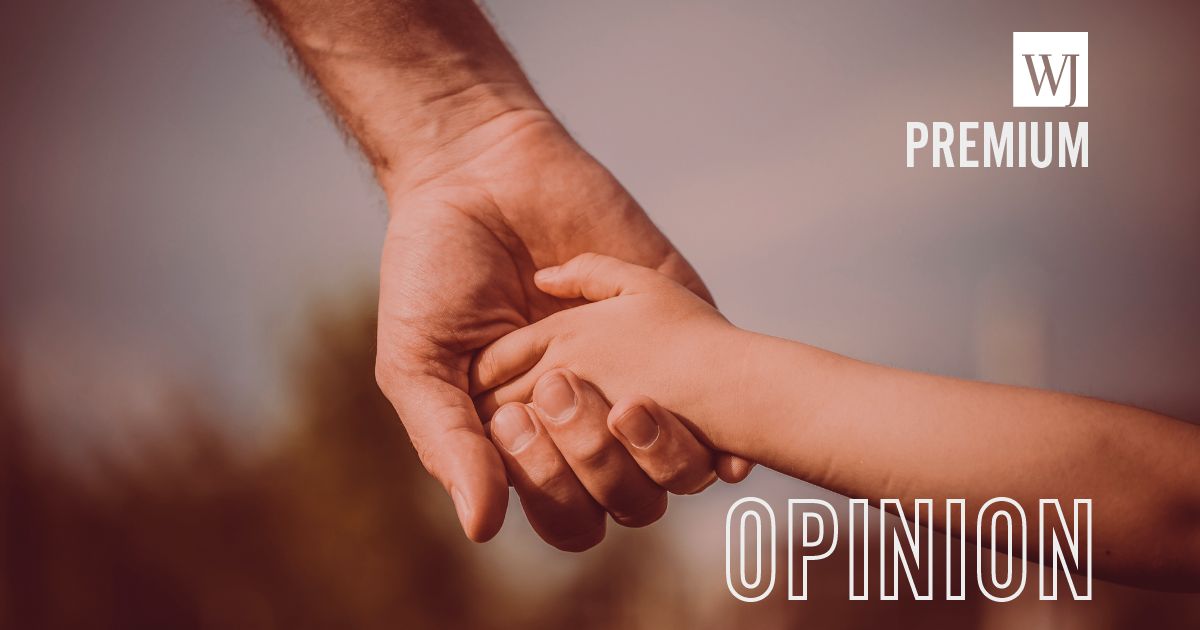 A father holds his child's hand in this stock image.