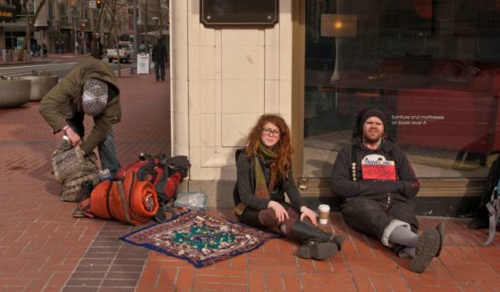 Several homeless people sit in front of Macy's on February 11, 2012 in Portland, Oregon.