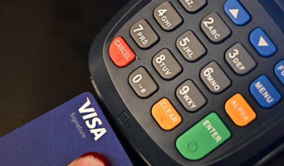 A credit card is placed into a credit card machine for processing payments on September 11, 2023 in La Puente, California.