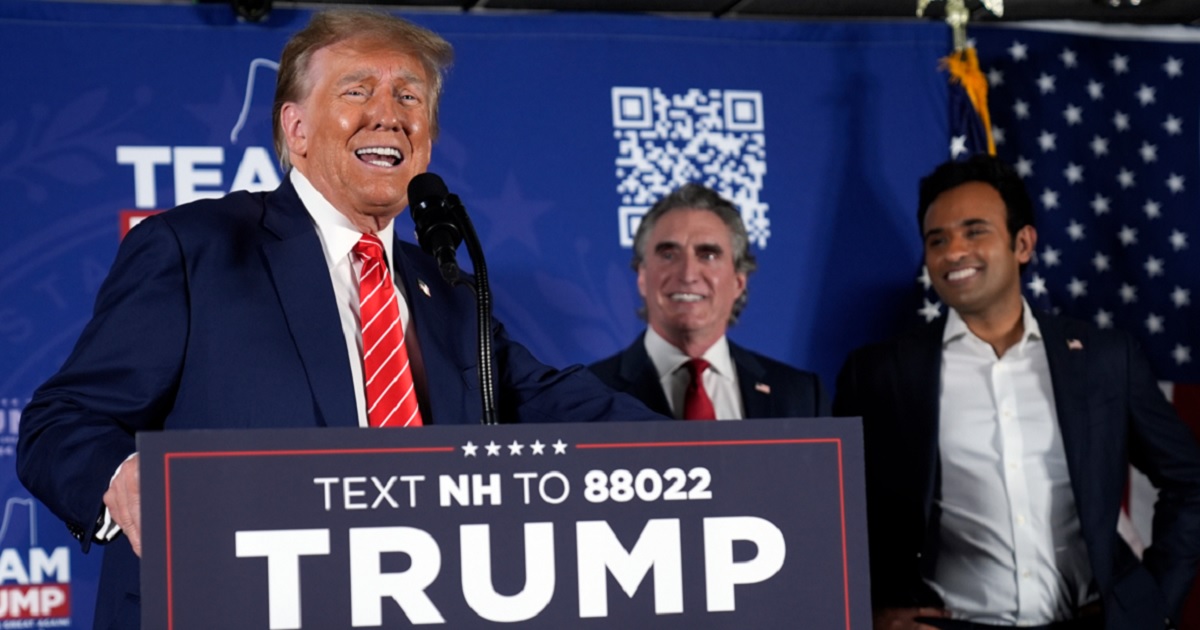 Former President Donald Trump speaks as former Republican presidential contenders North Dakota Gov. Doug Burgum, center, and Vivek Ramaswamy, right, appear on stage Monday during a campaign event in Laconia, New Hampshire.