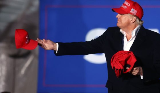 Former President Donald Trump, pictured at a 2022 rally in Florence, Arizona, tossing "Make America Great Again" hats to the crowd.