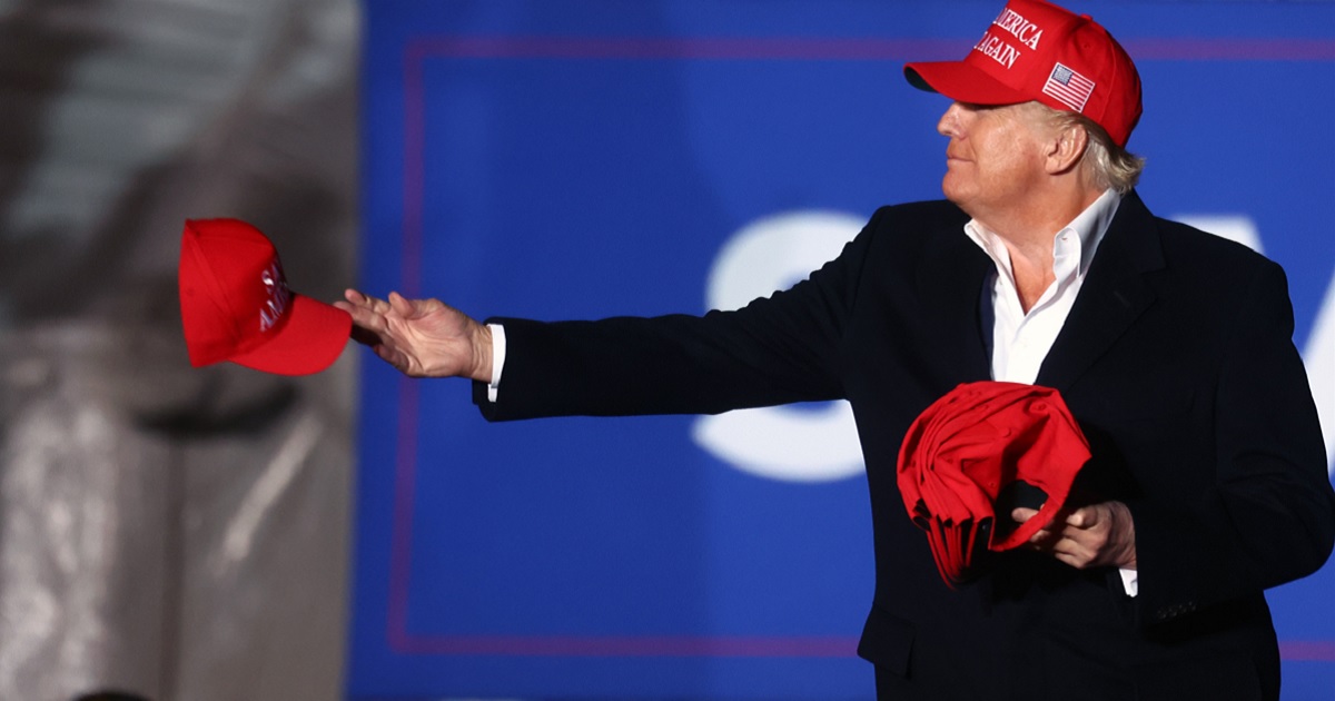 Former President Donald Trump, pictured at a 2022 rally in Florence, Arizona, tossing "Make America Great Again" hats to the crowd.