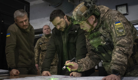 Ukrainian President Volodymyr Zelenskyy (center) and Col.-Gen. Oleksandr Syrskyi (far right) look at a map during a meeting in the front-line city of Kupiansk, Ukraine, on Nov. 30, 2023.