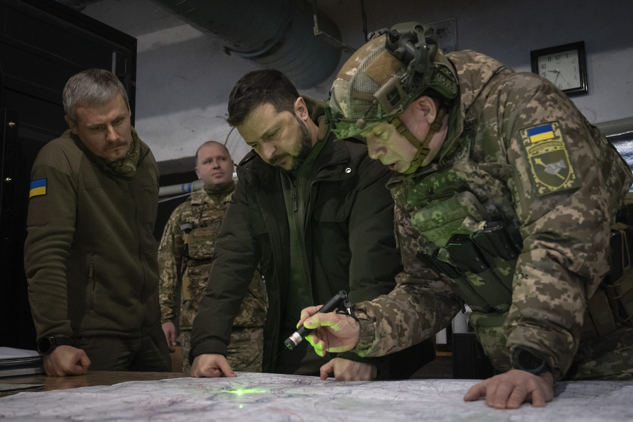 Ukrainian President Volodymyr Zelenskyy (center) and Col.-Gen. Oleksandr Syrskyi (far right) look at a map during a meeting in the front-line city of Kupiansk, Ukraine, on Nov. 30, 2023.