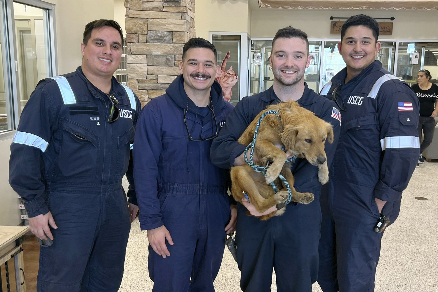 This image released by the U.S. Coast Guard, shows Connie the container dog, Wednesday with the four marine inspectors from the U.S. Coast Guard Sector Houston-Galveston who rescued her.