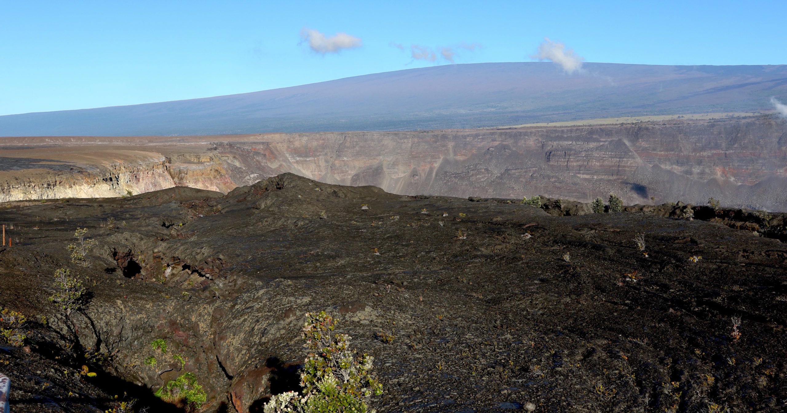 Hawaii's Mauna Loa volcano, background, towers over the summit crater of Kilauea volcano in Hawaii Volcanoes National Park on the Big Island on April 25, 2019.