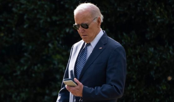 President Joe Biden looks at his phone as he walks to board Marine One on the South Lawn of the White House in Washington on Feb. 8.