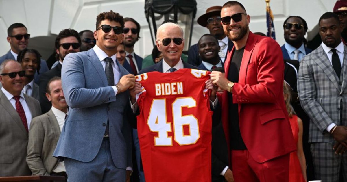 Kansas City Chiefs tight end Travis Kelce, right, and quarterback Patrick Mahomes, left, pose with President Joe Biden holding a jersey during the team's visit to the White House after winning the 2023 Super Bowl.