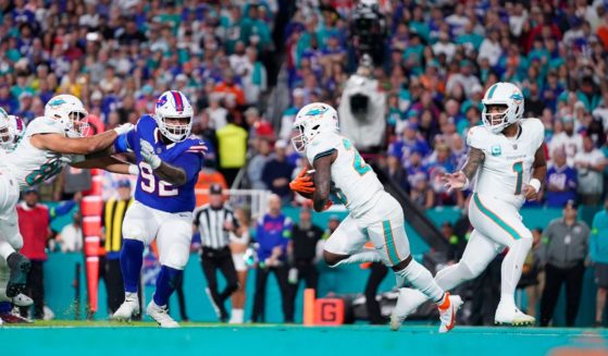 Tua Tagovailoa of the Miami Dolphins hands off to De'Von Achane during a game against the Buffalo Bills at Hard Rock Stadium in Miami Gardens, Florida, on Jan. 7.