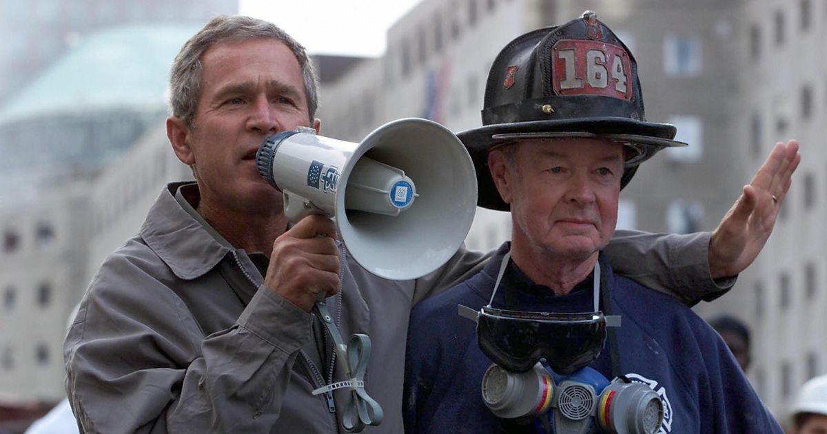 Then-President George W. Bush, left, stands next to retired firefighter Bob Beckwith as he speaks to firefighters and volunteers at the site of the World Trade Center in New York City on Sept. 14, 2001.