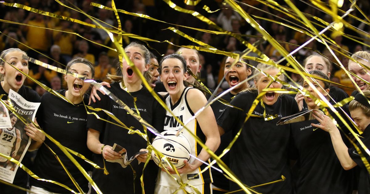 Caitlin Clark of the Iowa Hawkeyes celebrates with teammates during a presentation after breaking the NCAA women's all-time scoring record during a 106-89 victory over the Michigan Wolverines at Carver-Hawkeye Arena in Iowa City, Iowa, on Thursday.