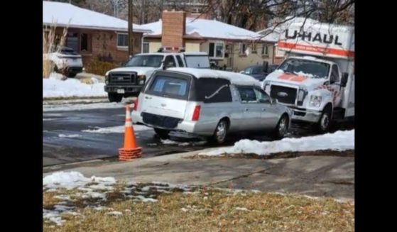 A hearse is seen outside a home in Denver.