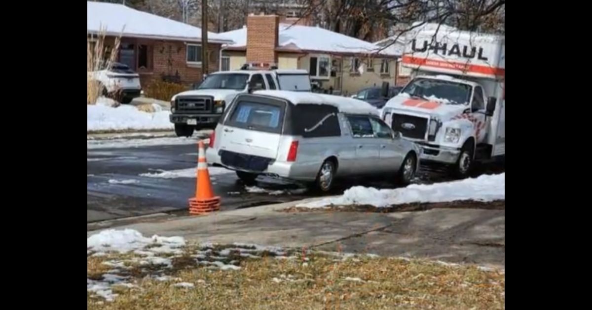 A hearse is seen outside a home in Denver.