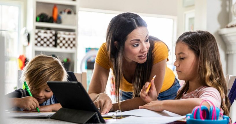 A stock photo shows a mom teaching her children at home. Michigan homeschoolers are gearing up to fight the state's plan to register their kids.