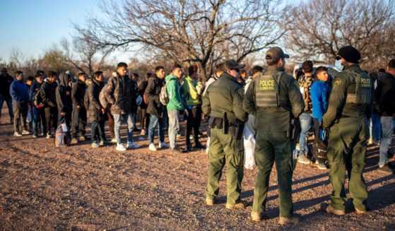 A group of migrants are processed by Border Patrol after crossing the river illegally near the highway on Feb. 4 outside Eagle Pass, Texas.