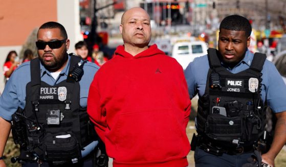 A man is detained by law enforcement following a shooting at Union Station during the Kansas City Chiefs Super Bowl victory parade on Wednesday.