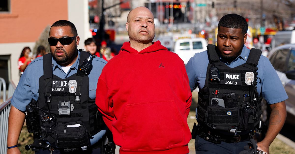A man is detained by law enforcement following a shooting at Union Station during the Kansas City Chiefs Super Bowl victory parade on Wednesday.