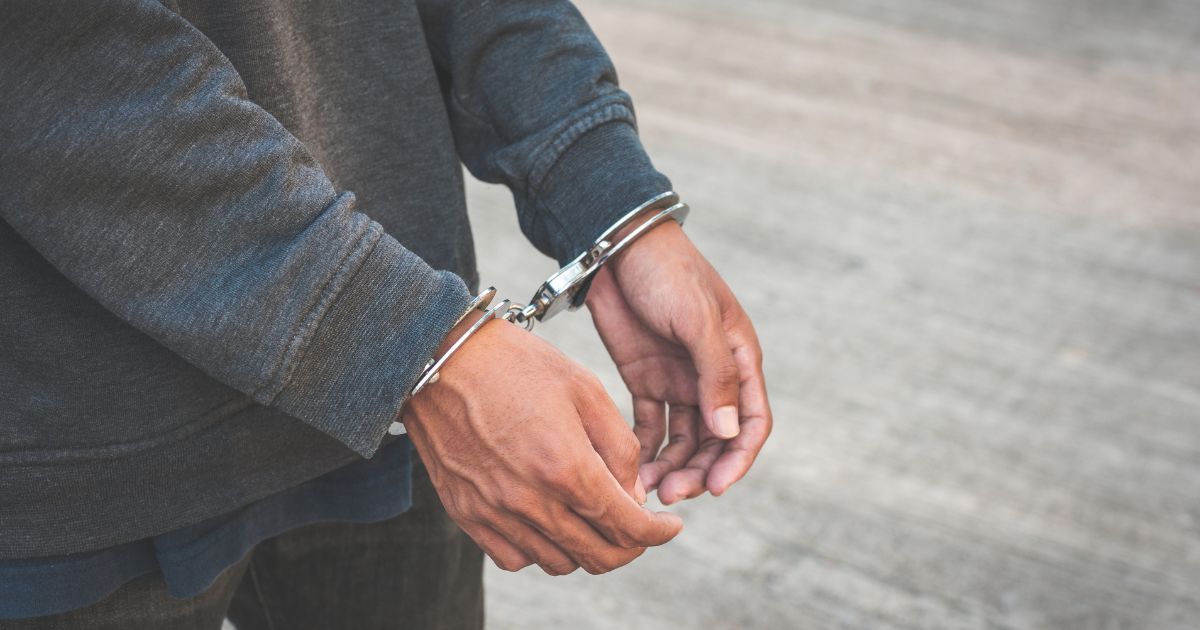 A close-up of a man wearing handcuffs.