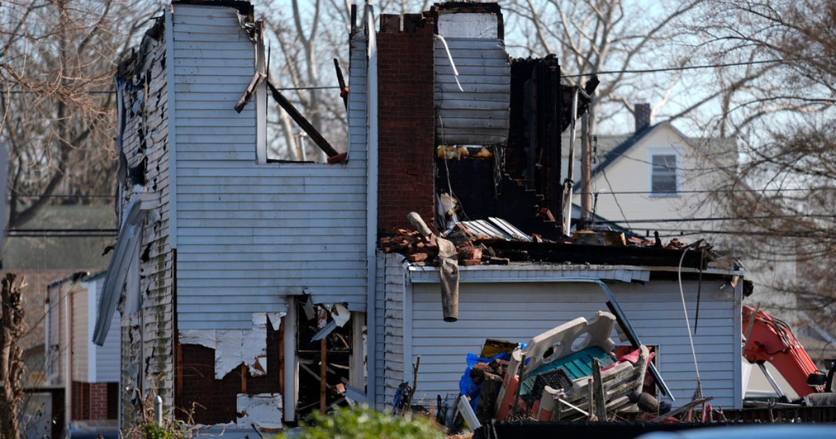 A home destroyed by from fire is shown in East Lansdowne, Pennsylvania, , Thursday. Authorities were searching the charred remains of the suburban Philadelphia home Thursday morning, a day after a shootout and fire left two police officers wounded and at least six people unaccounted for.