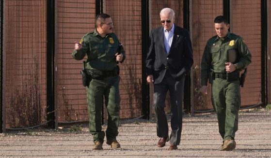Joe Biden walks with U.S. Border Patrol agents along a stretch of the U.S.-Mexico border