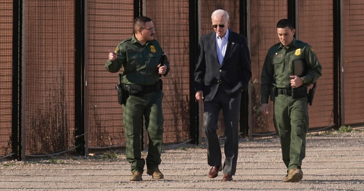Joe Biden walks with U.S. Border Patrol agents along a stretch of the U.S.-Mexico border