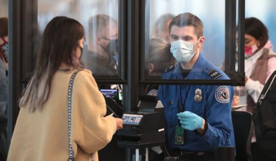 A Transportation Security Administration agent screens an airline passenger at O'Hare International Airport in October 2020 in Chicago, Illinois.