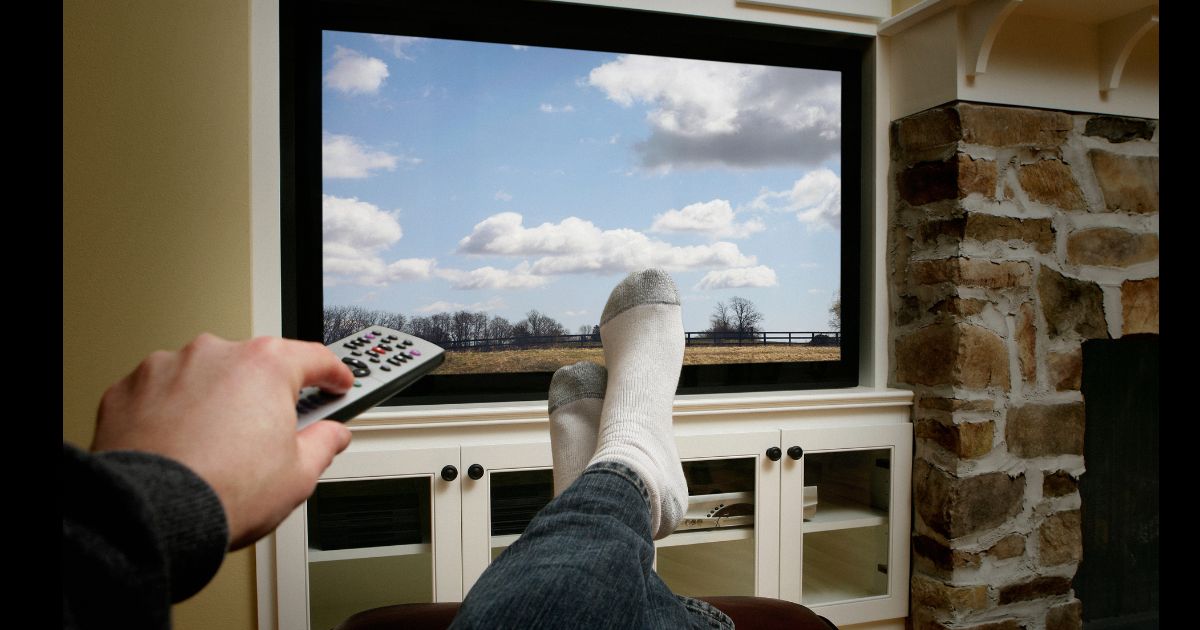 A person kicking back and watching some television.