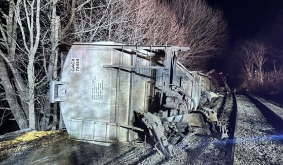 Two rail cars ended up in the Hoosic River, with two more teetering above it, in what was described as a "non-hazardous" spill resulting from a derailment in New York.
