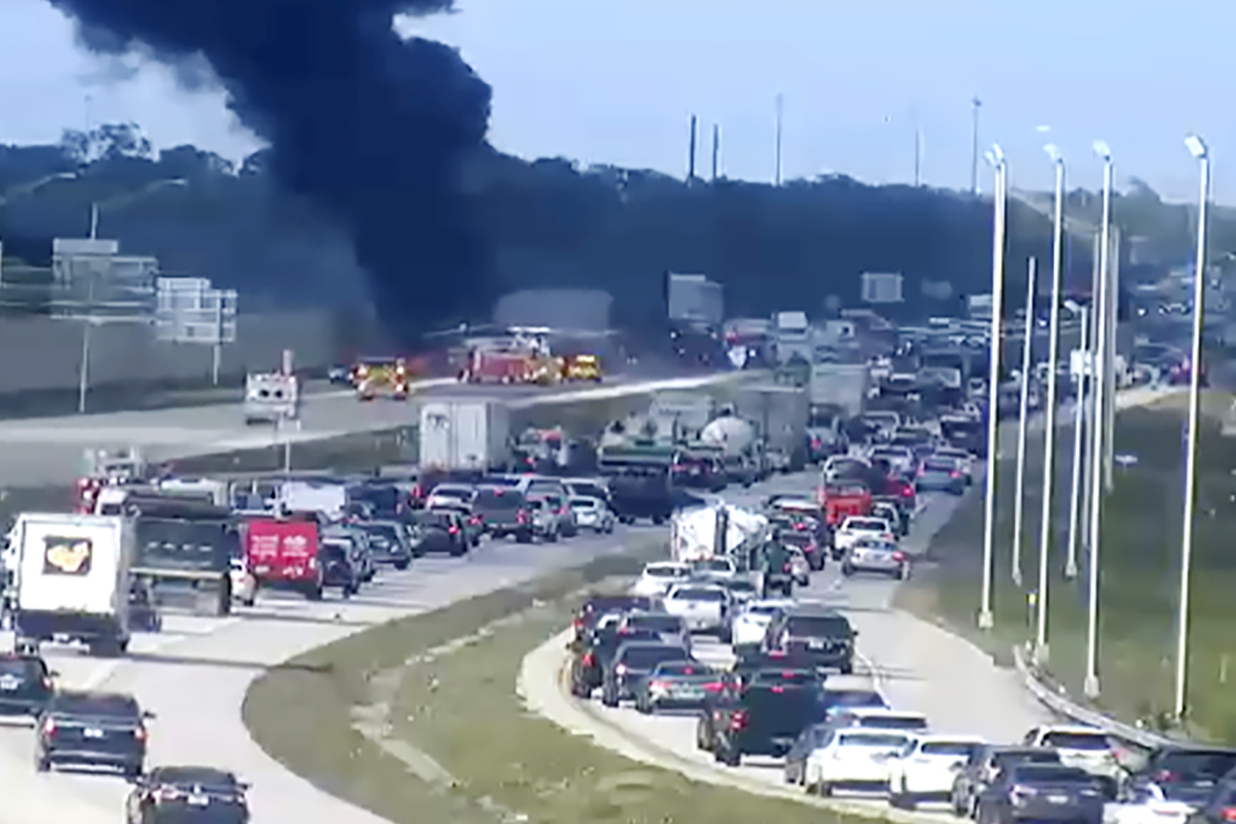 Smoke fills the air after an airplane crashed on Interstate 75 on Friday near Naples, Florida. Two people died in the crash.