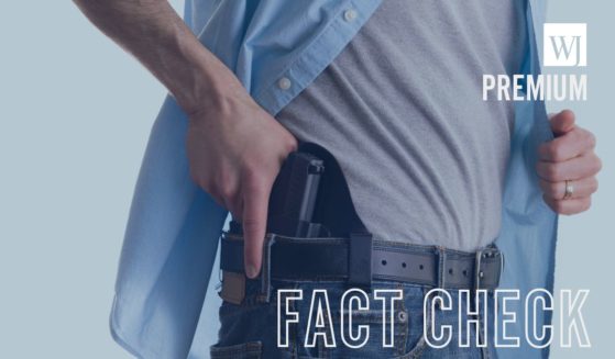 A man draws a gun from a holster in this stock image.