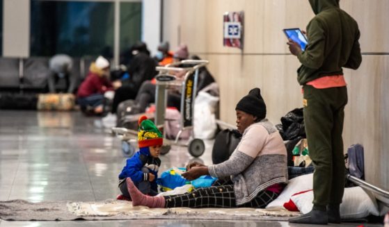 Migrant families are pictured in Boston's Logan International Airport in a Jan. 30 file photo. Private families in Massachusetts are being asked to open their homes to migrants as the state's shelter system is swamped.