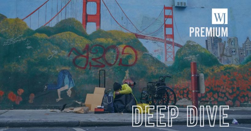 A homeless person lies against a mural of the Golden Gate Bridge on Nov. 11, 2023, in downtown San Francisco.