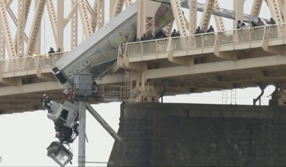 The driver of a semi-truck was pulled to safety Friday by firefighters in Louisville, Kentucky, following a crash that left the vehicle dangling over a bridge across the Ohio River.