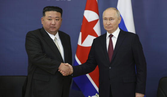 Russian President Vladimir Putin, right, and North Korea's leader Kim Jong Un are seen shaking hands in a file photo taken during a September meeting.