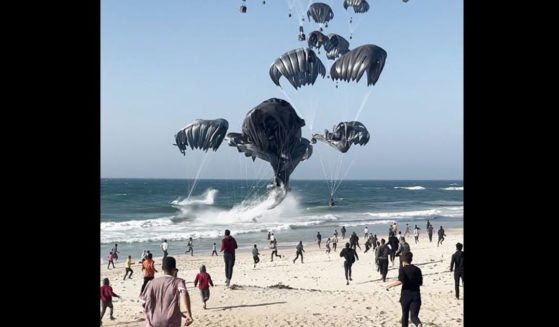 This image grab from an AFPTV video shows Palestinians running toward parachutes attached to food parcels, air-dropped from U.S. aircrafts on a beach in the Gaza Strip on March 2.